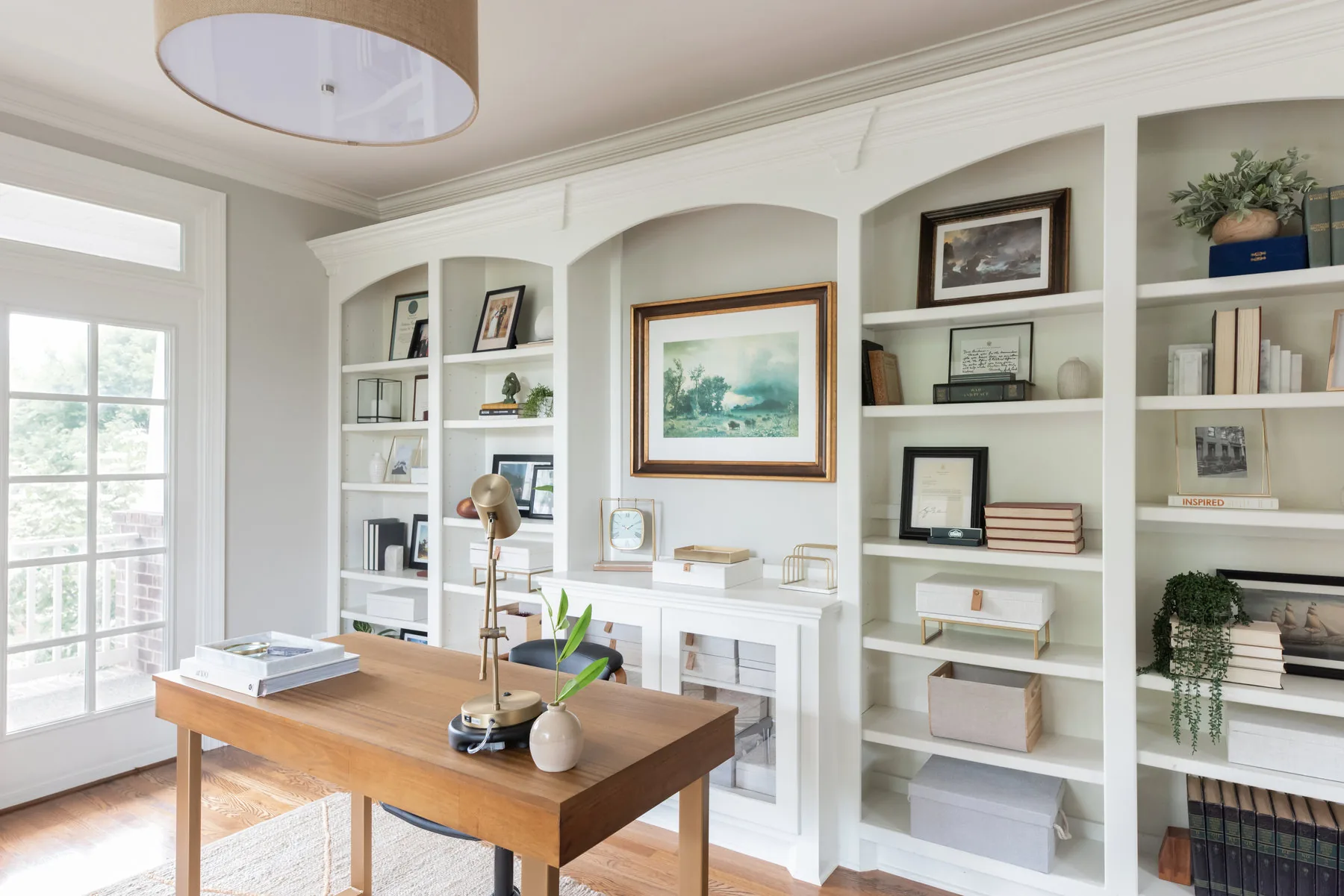 Bright home office with white built-in shelving designed by Shelter + Sanctuary